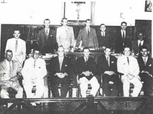 Câmara Municipal no período legislativo 1956/1959, que era composta por 15 vereadores. (1) o secretário Moacyr França, (2) José Antônio Salgado (PRP), (3) o presidente José de Paula Leão (PSD), (4) Otáclito Barbosa (PSD), (5) Antônio Silva de Oliveira (PSP-PTB), (6) Adhemar Cassiano (PSD), (7) Hélvio Nunes da Silva (“Zito”) (PPS–PTB), (8) Alfredo Cardoso Pimenta (UDN), (9) Dr. Cláudio Guimarães César (PSD), (10) Severino Spesizano (PSD), (11) Filipe Liporaci Neto (“Titióla”) (PPS-PTB), (12 ) Arary Simpliciano Barbosa (PPS- PTB), (13) Dr. José Alípio Furquim Fonseca (UDN), (14) Manoel Pontes Neto “Nelinho” (PSD). Também eram vereadores e não estão na foto, Jesus Rodrigues (“Capucha”) (PSD) e Abrão Miguel (“Assod”) (PPS-PTB)